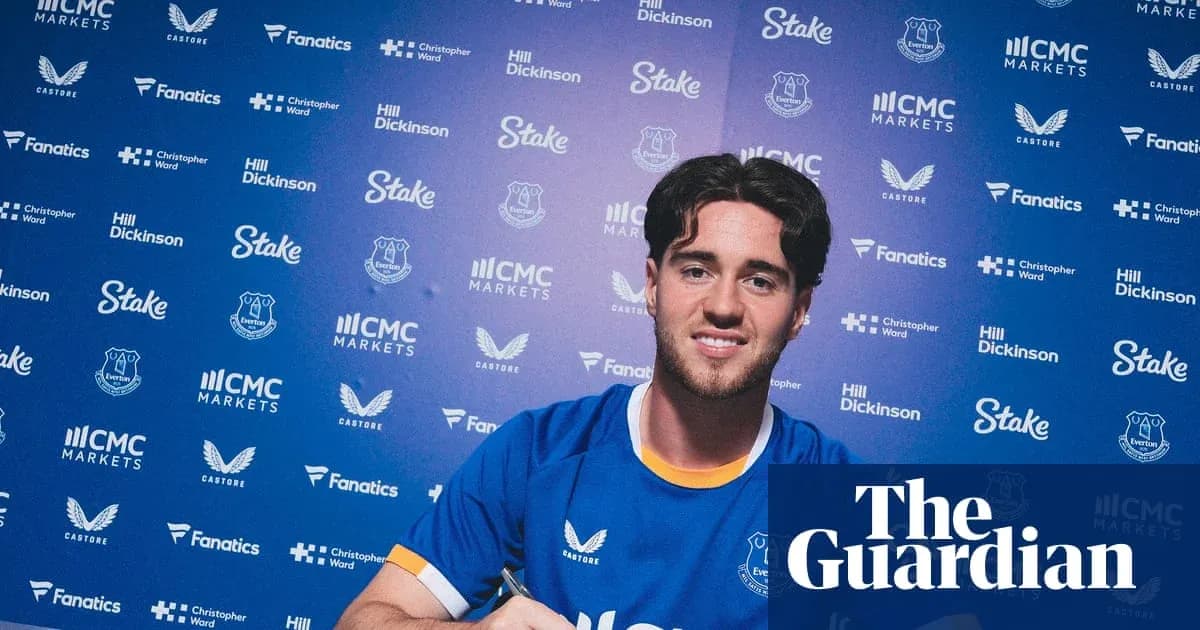Joueur d'Everton signant un contrat devant des logos Joueur d'Everton signant un contrat devant des logos