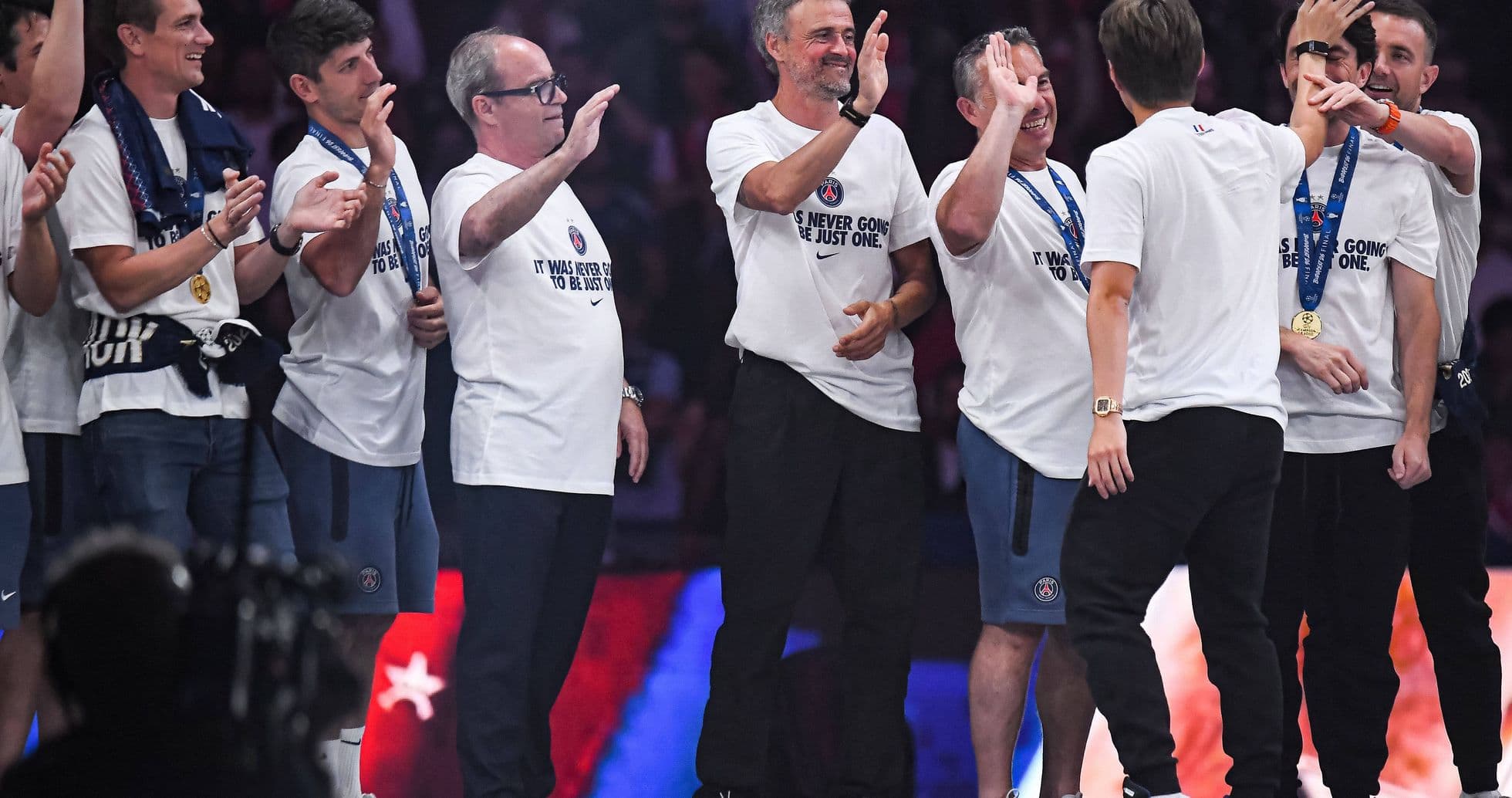 Équipe célébrant une victoire sur scène avec médailles Équipe célébrant une victoire sur scène avec médailles