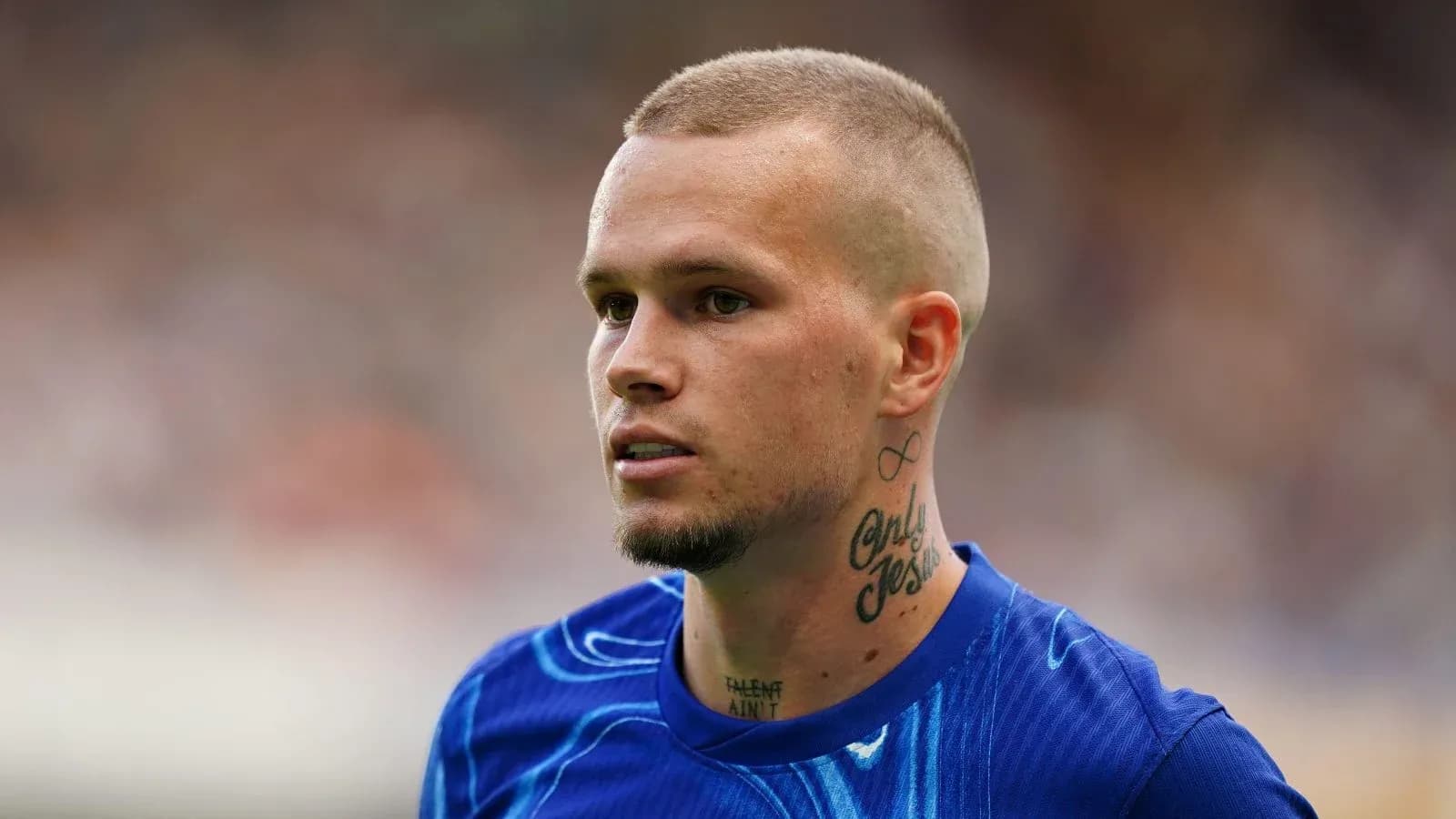 Joueur de football avec tatouages, en tenue d'entraînement Joueur de football avec tatouages, en tenue d'entraînement