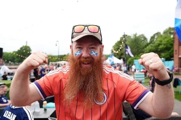 Supporter celebrating with Scottish flag face paint Supporter celebrating with Scottish flag face paint