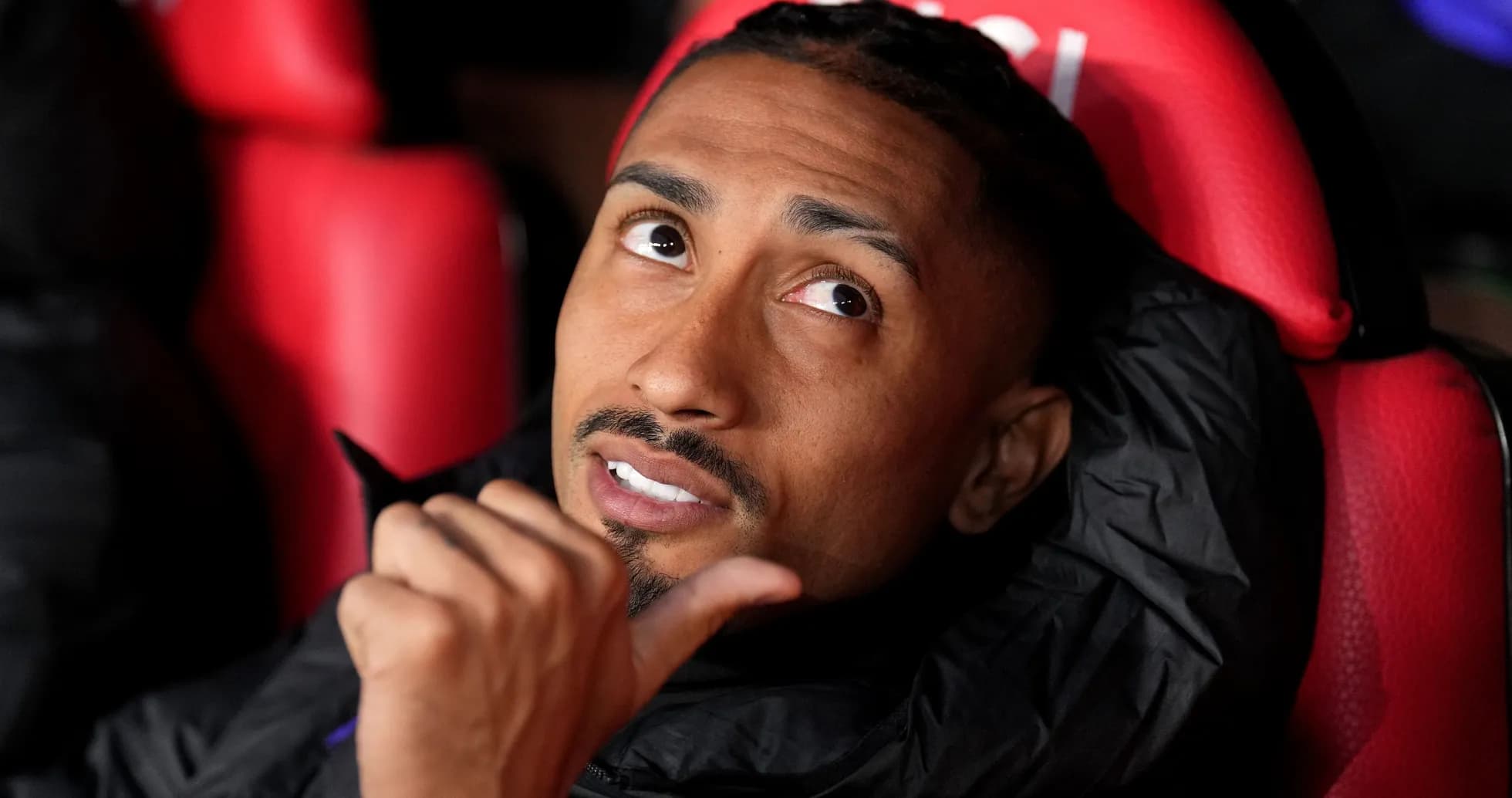 Joueur assis sur le banc de touche, regardant autour Joueur assis sur le banc de touche, regardant autour