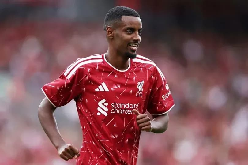 Joueur de Liverpool en maillot rouge souriant sur le terrain Joueur de Liverpool en maillot rouge souriant sur le terrain