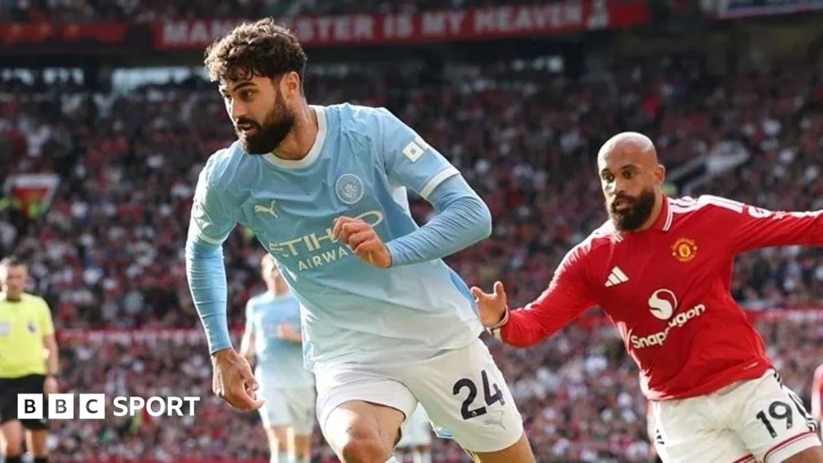 Joueur de Manchester City dribblant un adversaire de Manchester United Joueur de Manchester City dribblant un adversaire de Manchester United