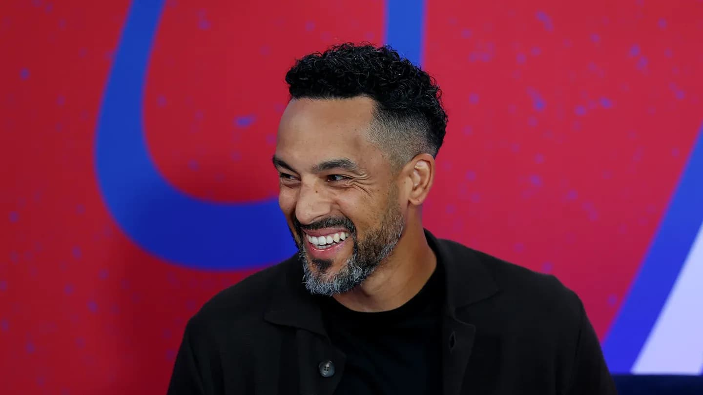 Homme souriant lors d'un événement médiatique Homme souriant lors d'un événement médiatique