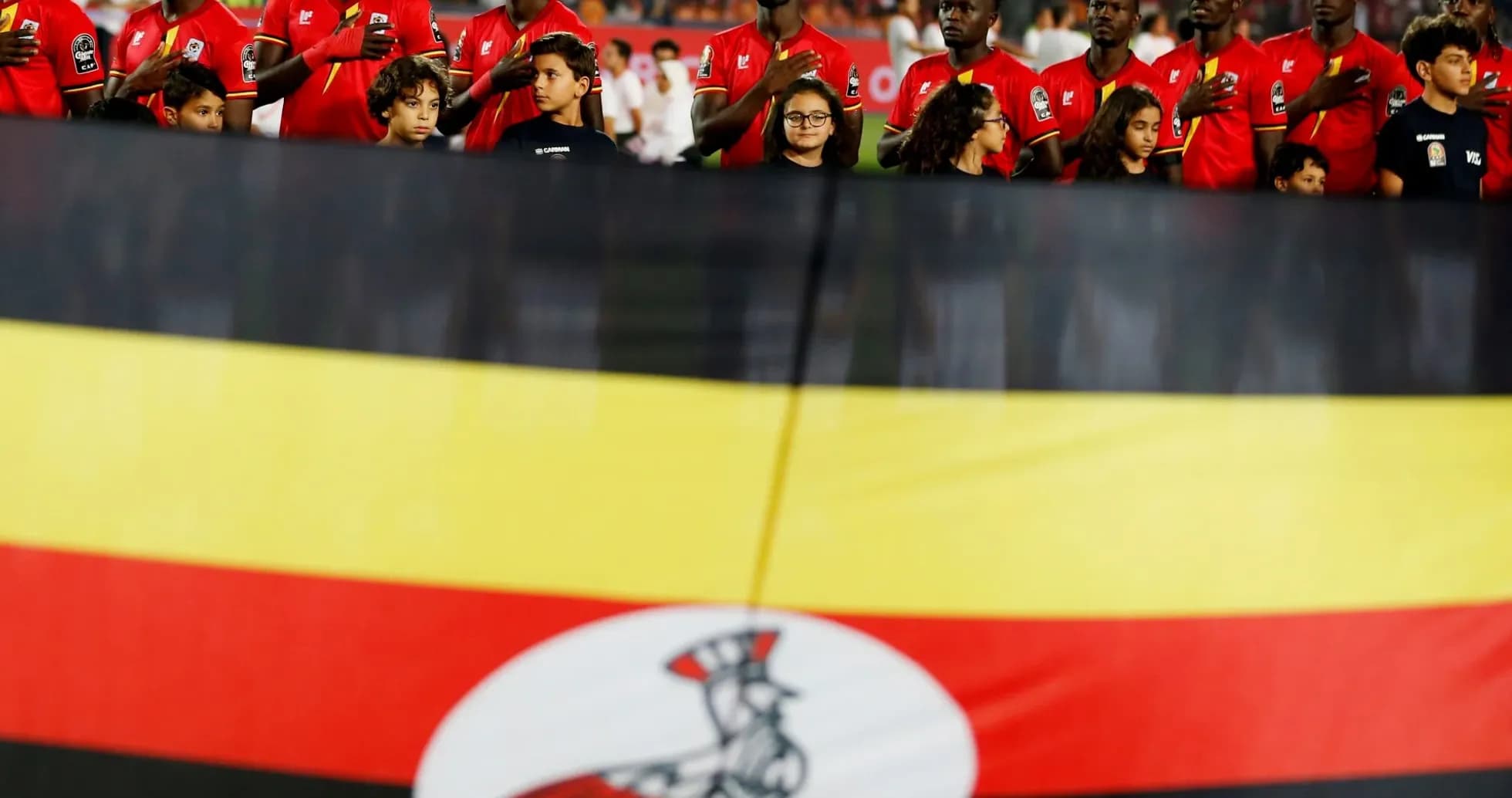 Joueurs et enfants avec le drapeau de l'Ouganda Joueurs et enfants avec le drapeau de l'Ouganda