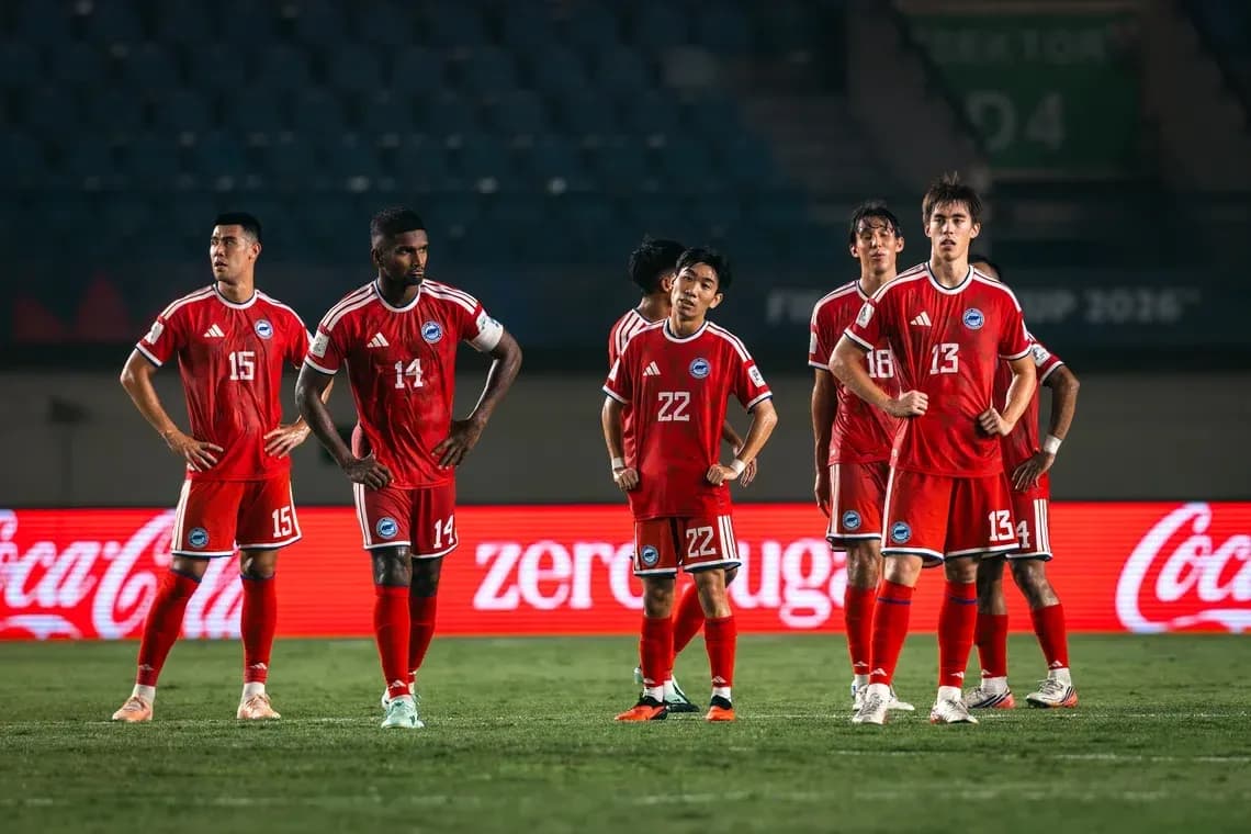 Joueurs en maillots rouges se regroupant sur le terrain Joueurs en maillots rouges se regroupant sur le terrain