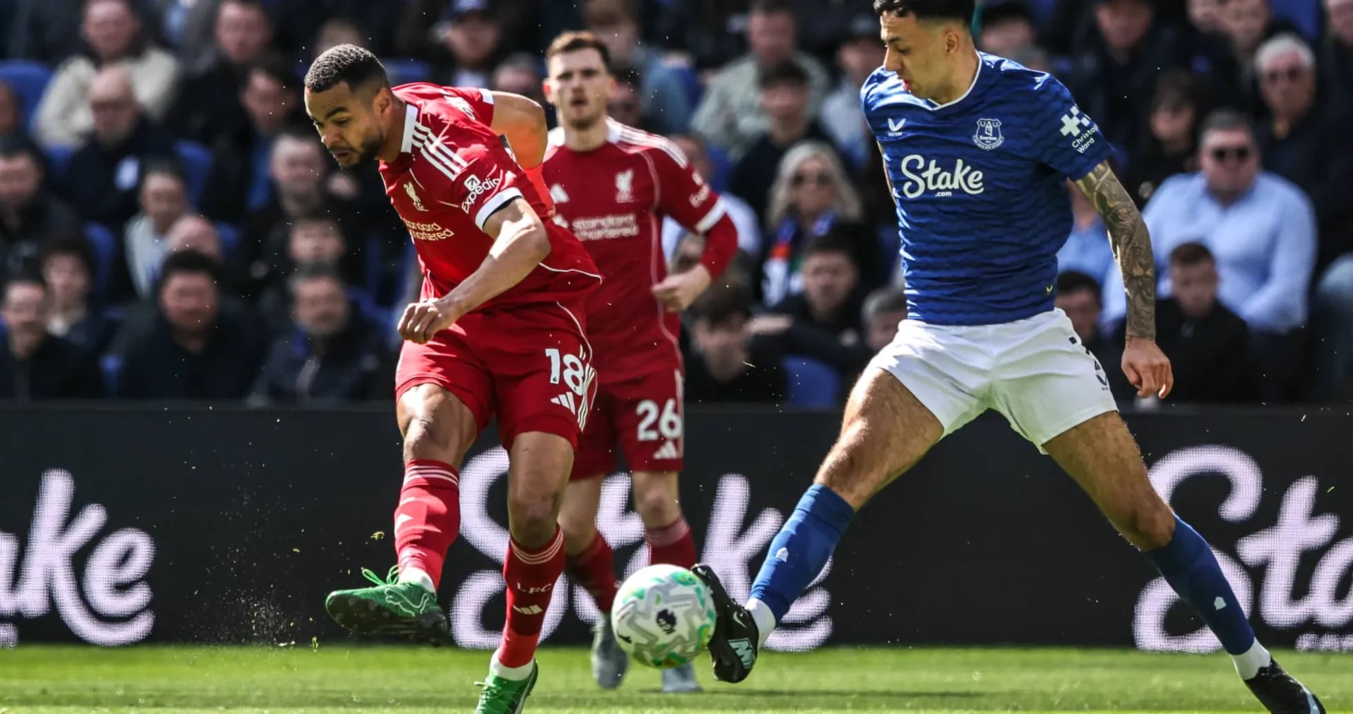 Joueur de Liverpool dribblant un adversaire d'Everton Joueur de Liverpool dribblant un adversaire d'Everton