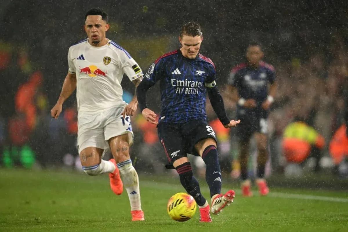 Joueur d'Arsenal dribblant sous la pluie Joueur d'Arsenal dribblant sous la pluie