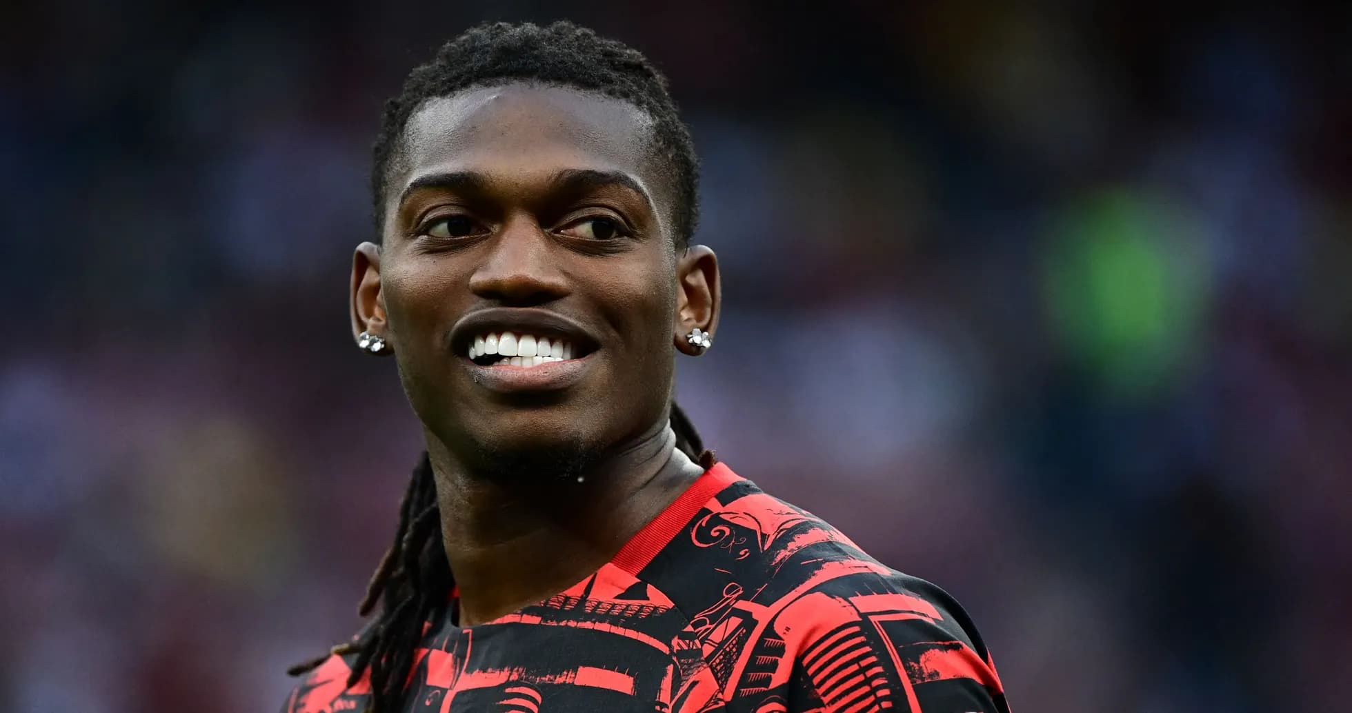 Joueur souriant en tenue d'entraînement rouge et noir Joueur souriant en tenue d'entraînement rouge et noir
