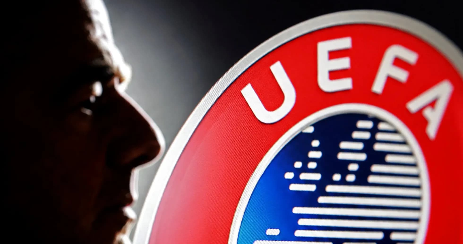 Silhouette d'un homme devant le logo de l'UEFA Silhouette d'un homme devant le logo de l'UEFA