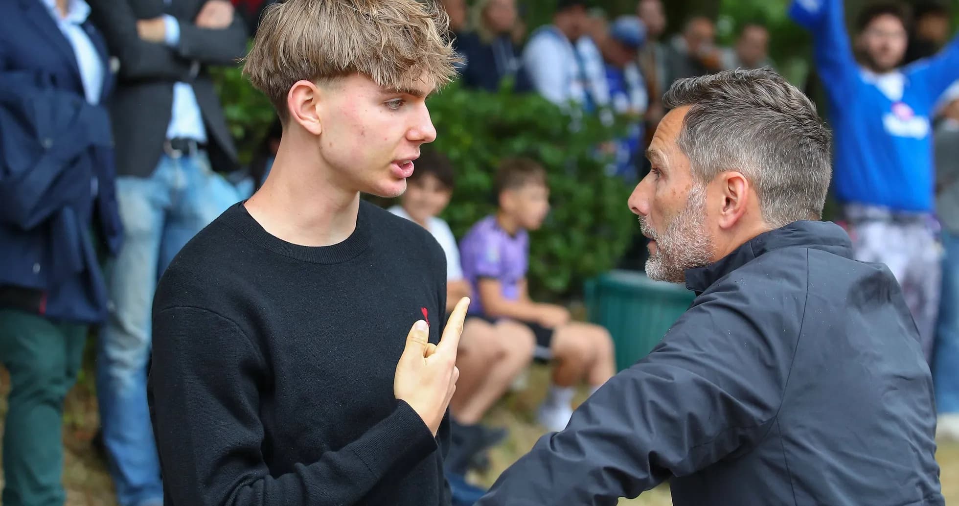 Discussion between two individuals near a crowd Discussion between two individuals near a crowd