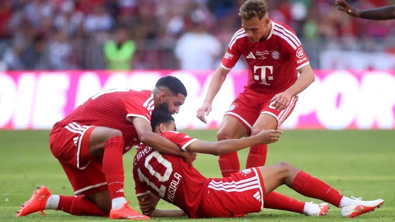 Joueurs de Bayern Munich aidant un coéquipier au sol Joueurs de Bayern Munich aidant un coéquipier au sol