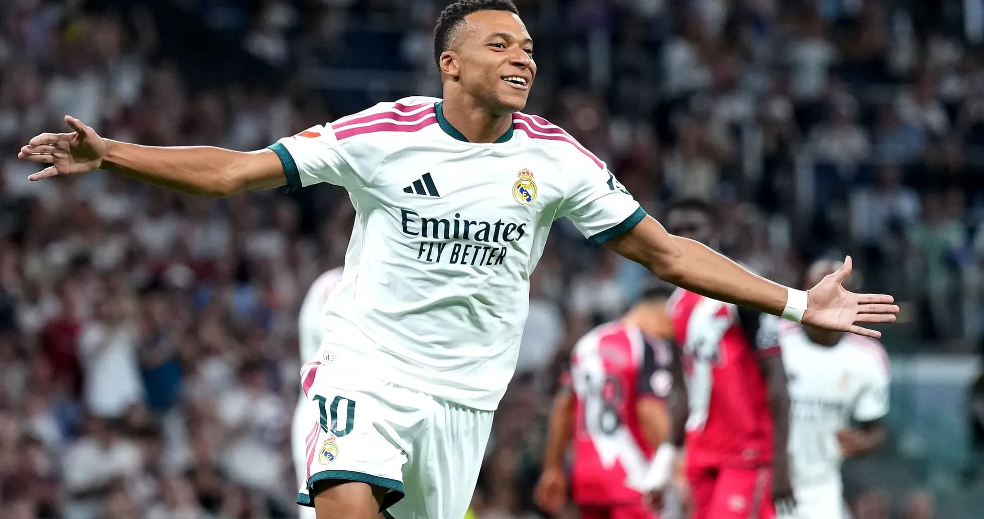 Joueur de football célébrant un but avec les bras ouverts Joueur de football célébrant un but avec les bras ouverts