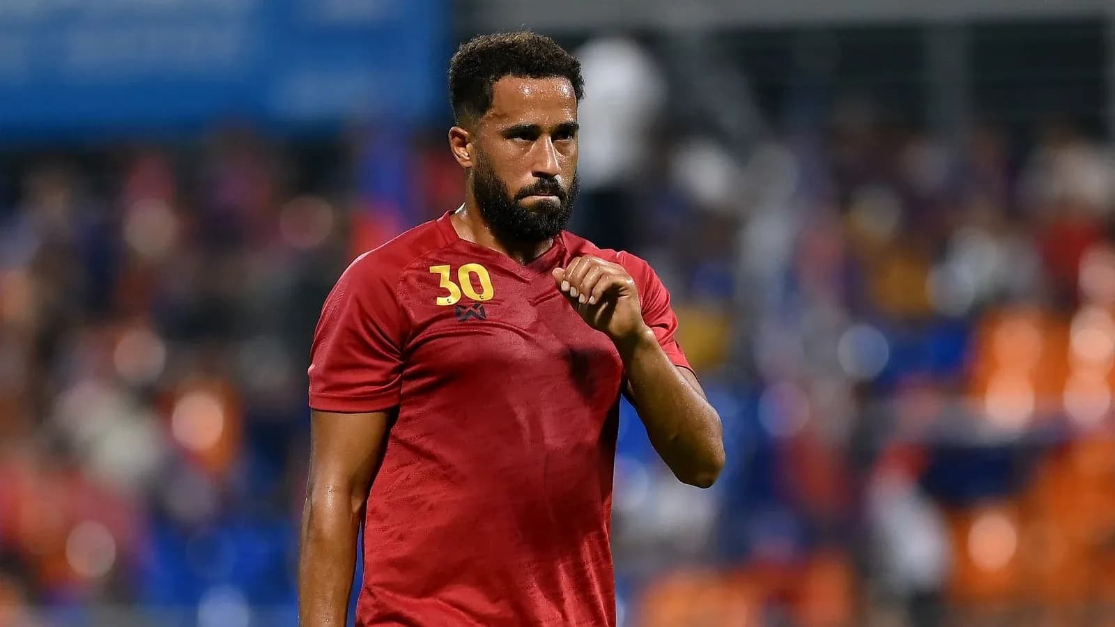 Joueur en maillot rouge sur le terrain de football Joueur en maillot rouge sur le terrain de football