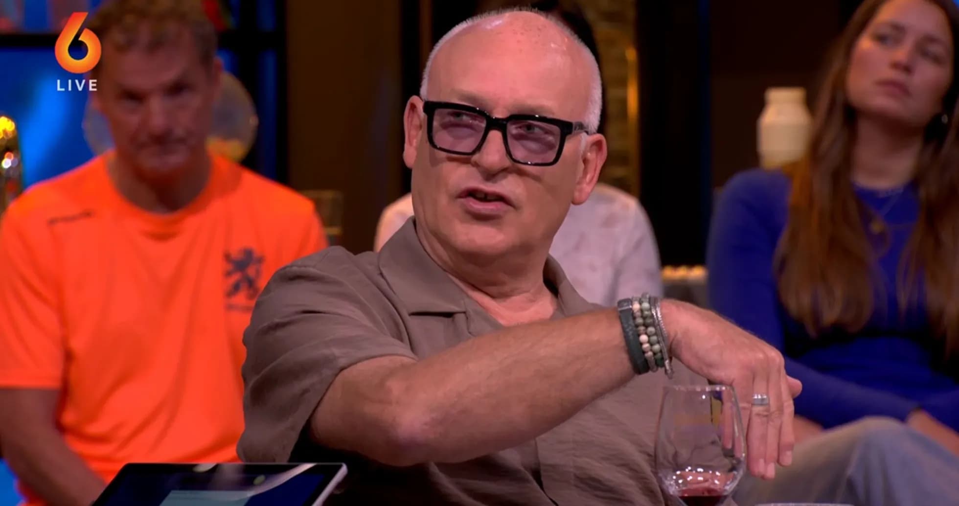 Homme parlant avec un verre de vin en main Homme parlant avec un verre de vin en main