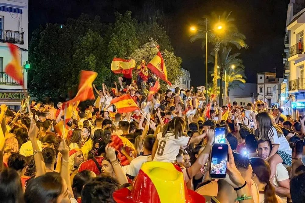 Foule célébrant avec drapeaux espagnols en soirée Foule célébrant avec drapeaux espagnols en soirée