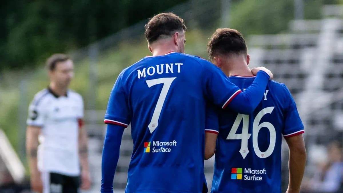 Deux joueurs en maillots bleus se parlent sur le terrain Deux joueurs en maillots bleus se parlent sur le terrain