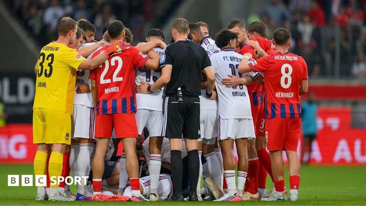 Joueurs entourant un coéquipier blessé sur le terrain Joueurs entourant un coéquipier blessé sur le terrain