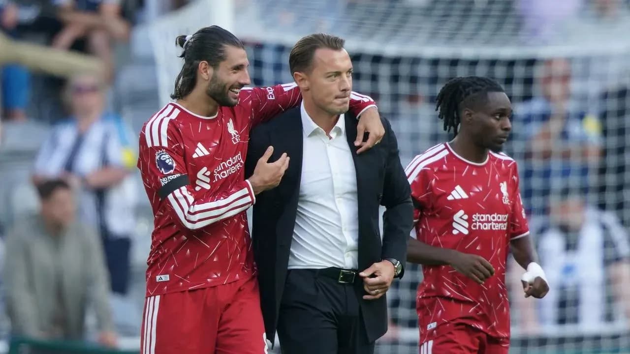 Joueurs de Liverpool entourant un entraîneur sur le terrain Joueurs de Liverpool entourant un entraîneur sur le terrain