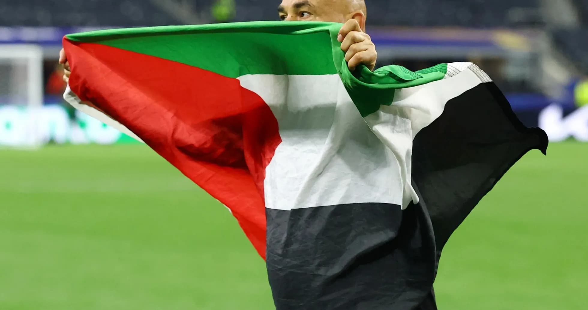 Homme tenant un drapeau sur le terrain de football Homme tenant un drapeau sur le terrain de football