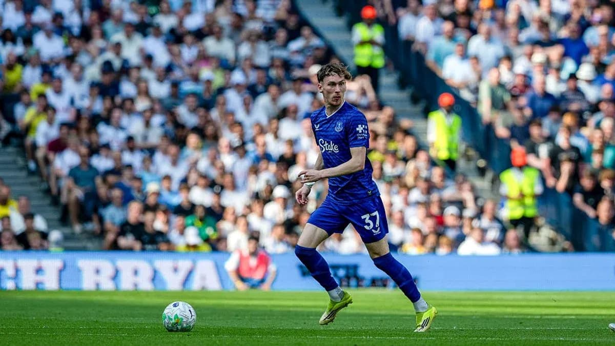 Joueur en bleu courant avec le ballon sur le terrain Joueur en bleu courant avec le ballon sur le terrain
