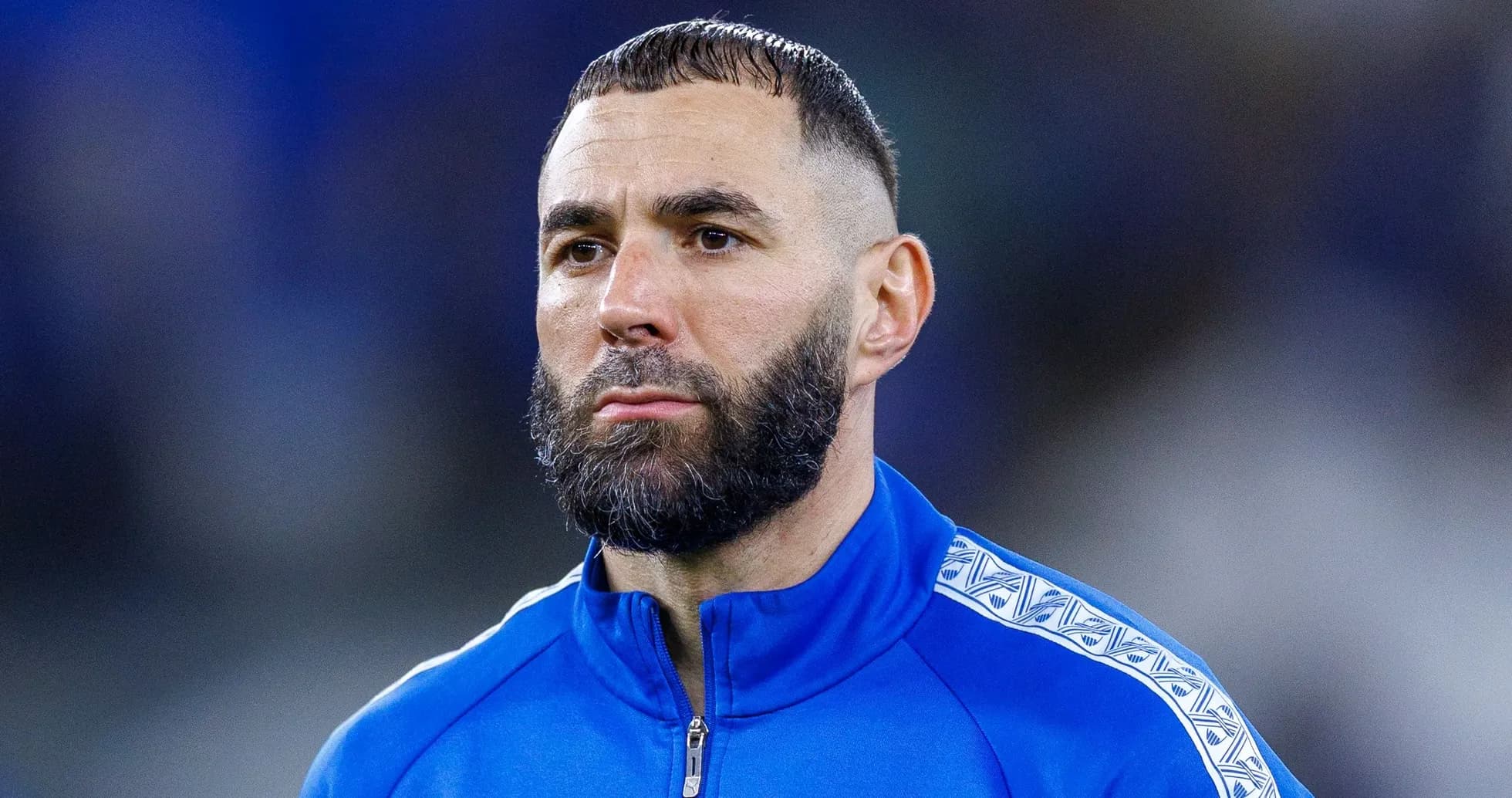 Joueur en tenue bleue, regard sérieux avant le match Joueur en tenue bleue, regard sérieux avant le match