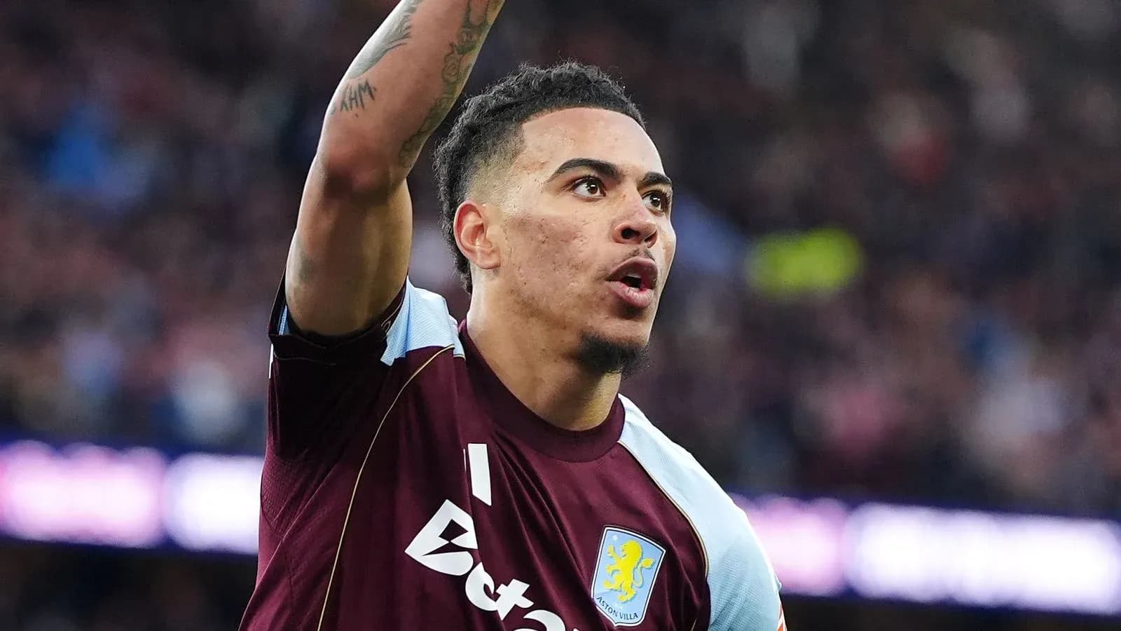 Joueur d'Aston Villa levant le bras sur le terrain Joueur d'Aston Villa levant le bras sur le terrain