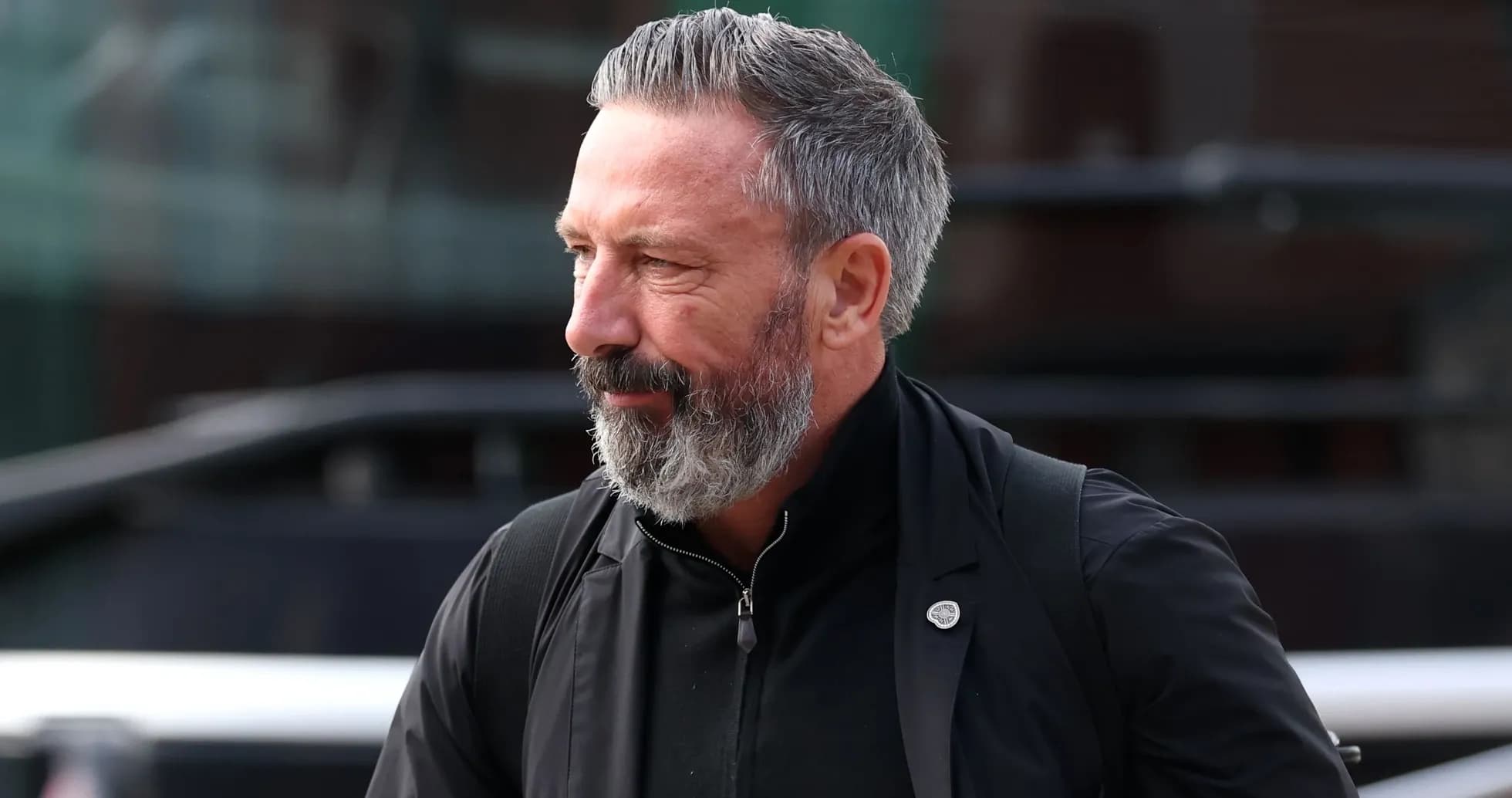 Homme avec barbe grise marchant près d'un bus Homme avec barbe grise marchant près d'un bus