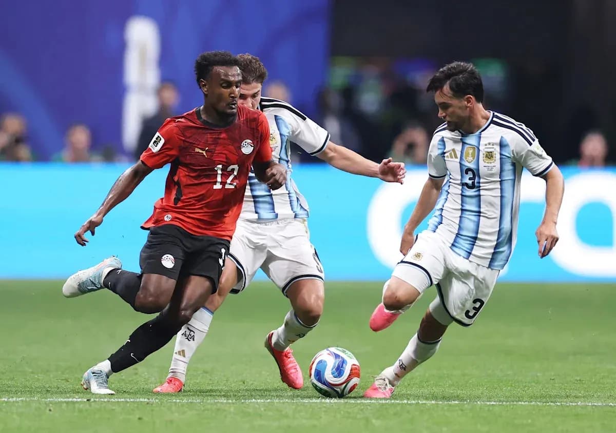 Joueur égyptien dribblant entre deux joueurs argentins Joueur égyptien dribblant entre deux joueurs argentins