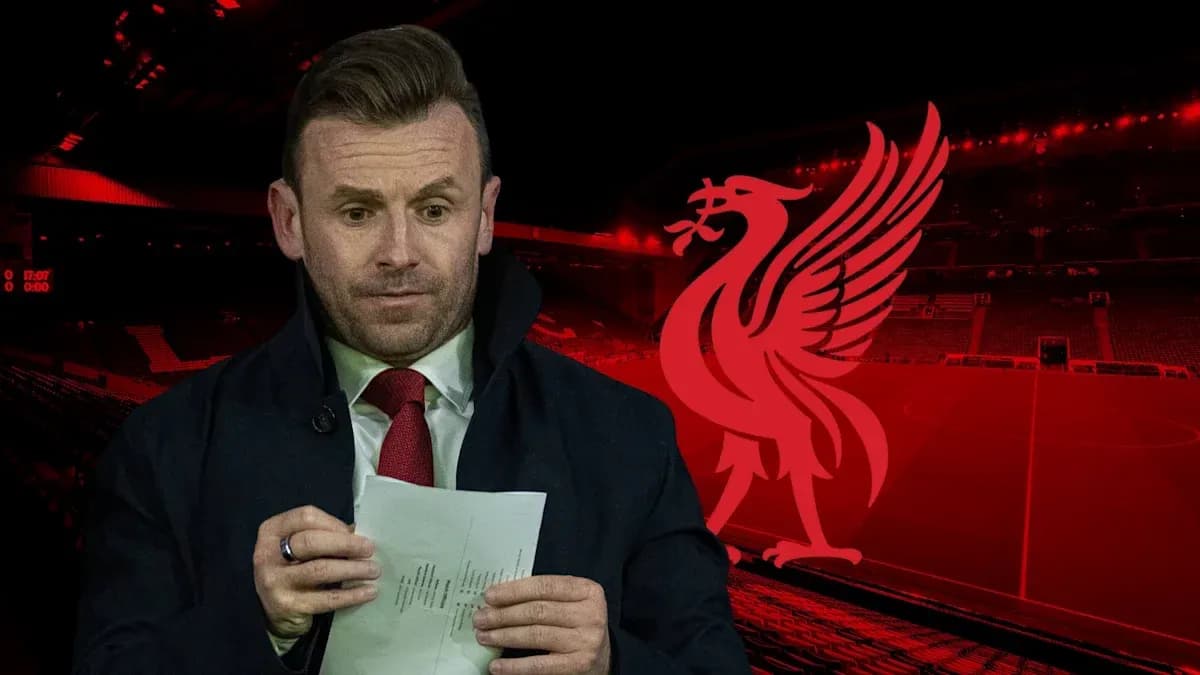 Analyste tenant une feuille devant le logo de Liverpool Analyste tenant une feuille devant le logo de Liverpool