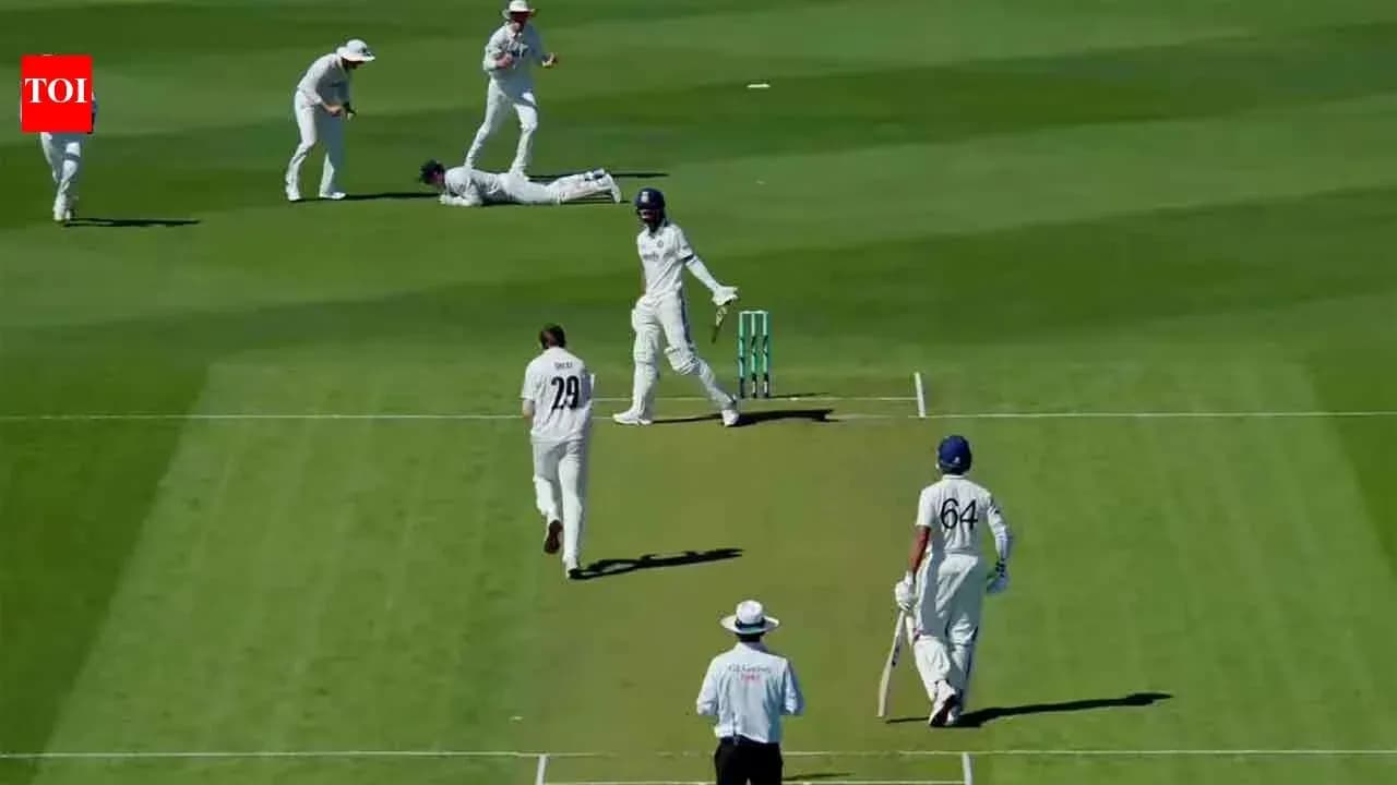 Joueurs de cricket sur le terrain, un joueur au sol Joueurs de cricket sur le terrain, un joueur au sol