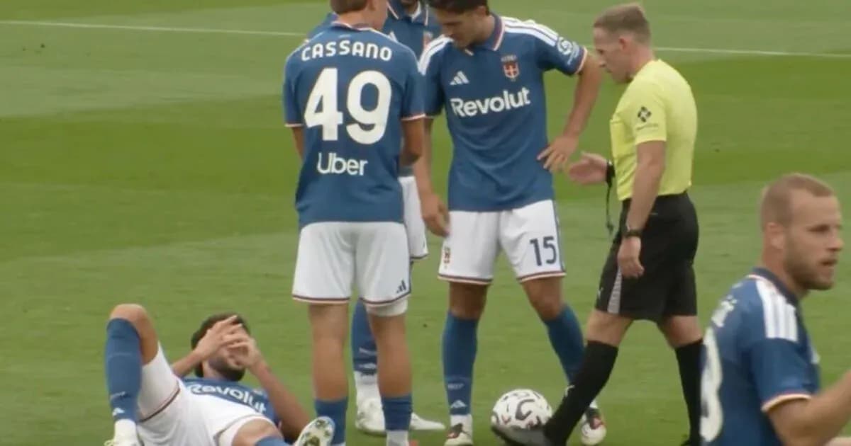 Joueur blessé au sol avec coéquipiers et arbitre Joueur blessé au sol avec coéquipiers et arbitre