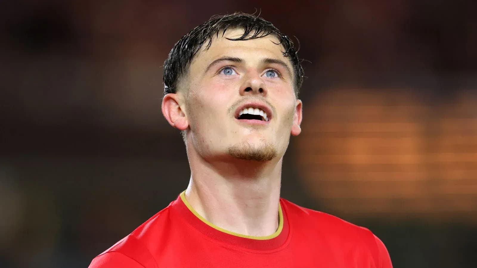 Joueur en maillot rouge regardant vers le ciel Joueur en maillot rouge regardant vers le ciel