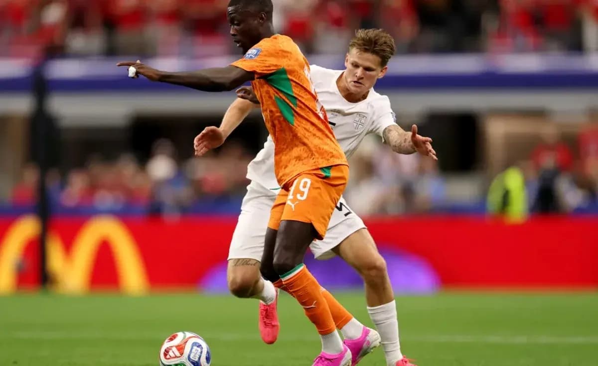 Joueur en orange dribblant sous la pression d'un adversaire Joueur en orange dribblant sous la pression d'un adversaire