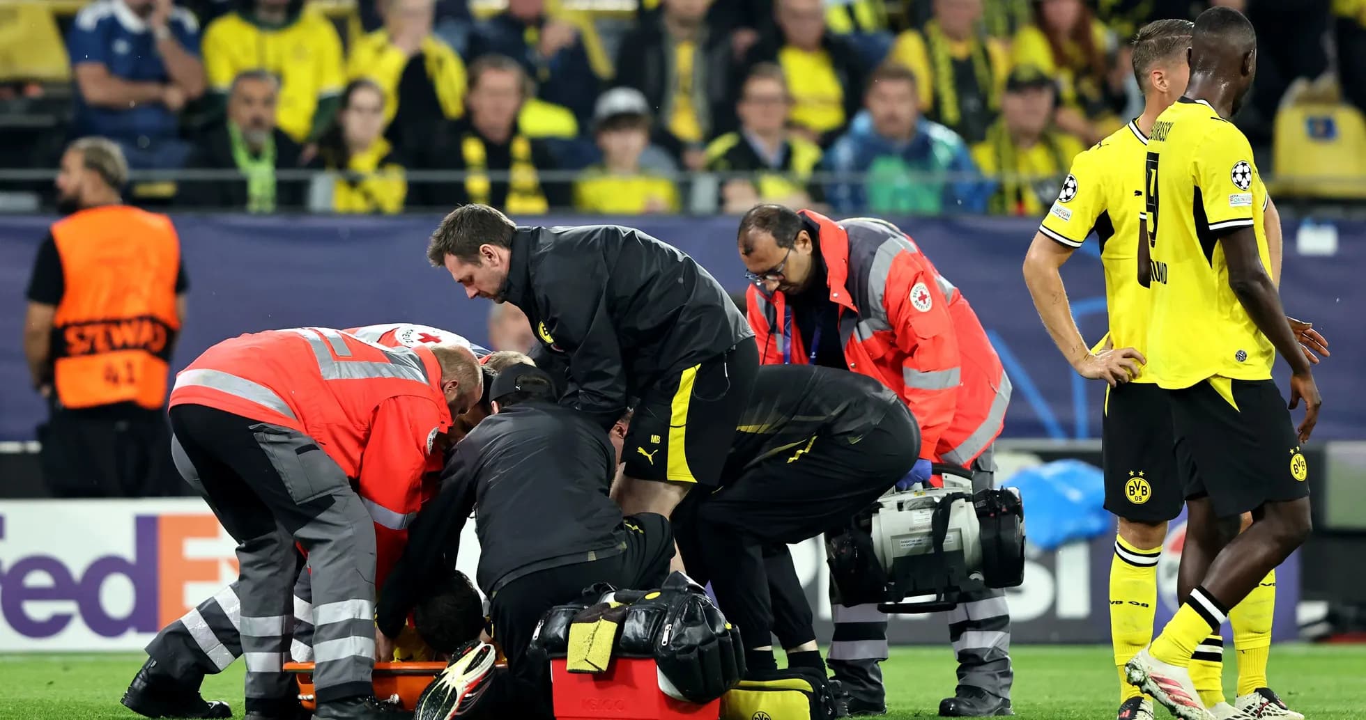 Secours médical autour d'un joueur blessé sur le terrain Secours médical autour d'un joueur blessé sur le terrain