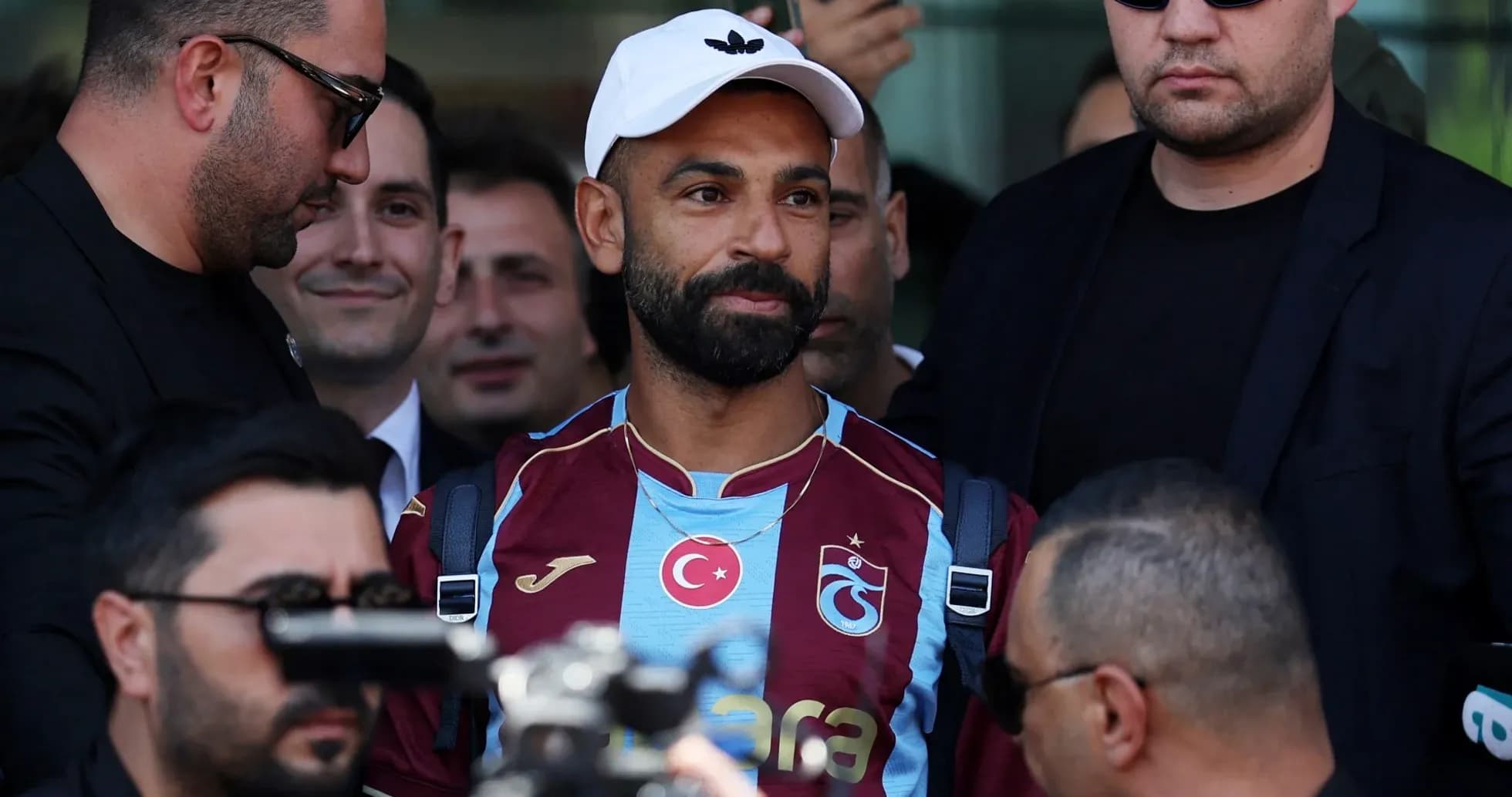 Joueur avec maillot Trabzonspor entouré de sécurité Joueur avec maillot Trabzonspor entouré de sécurité