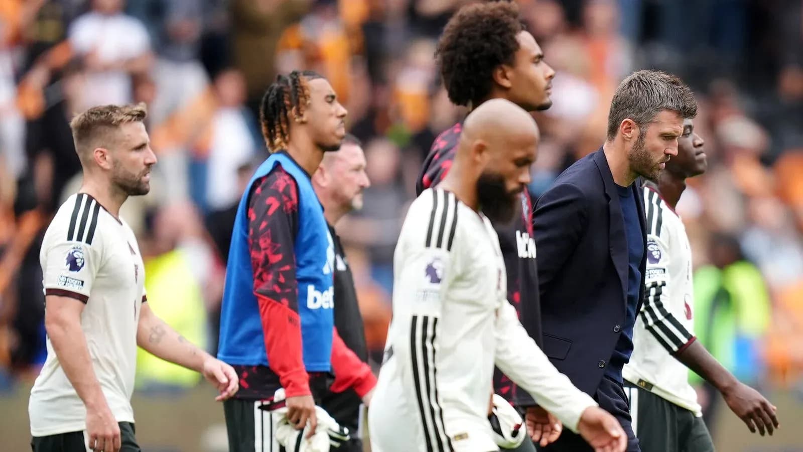 Joueurs et entraîneur quittant le terrain après le match Joueurs et entraîneur quittant le terrain après le match