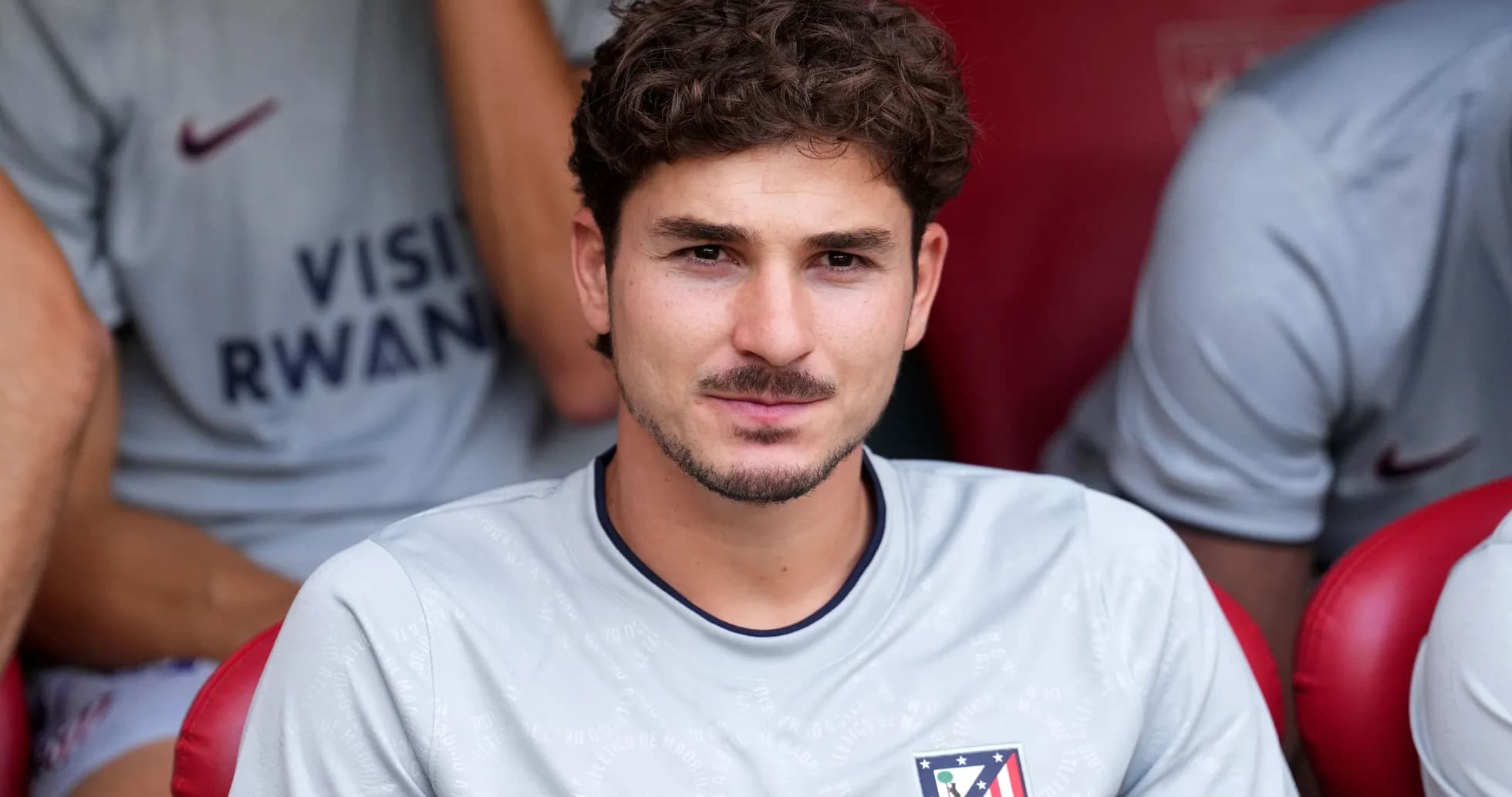 Joueur assis sur le banc de touche, maillot gris Joueur assis sur le banc de touche, maillot gris