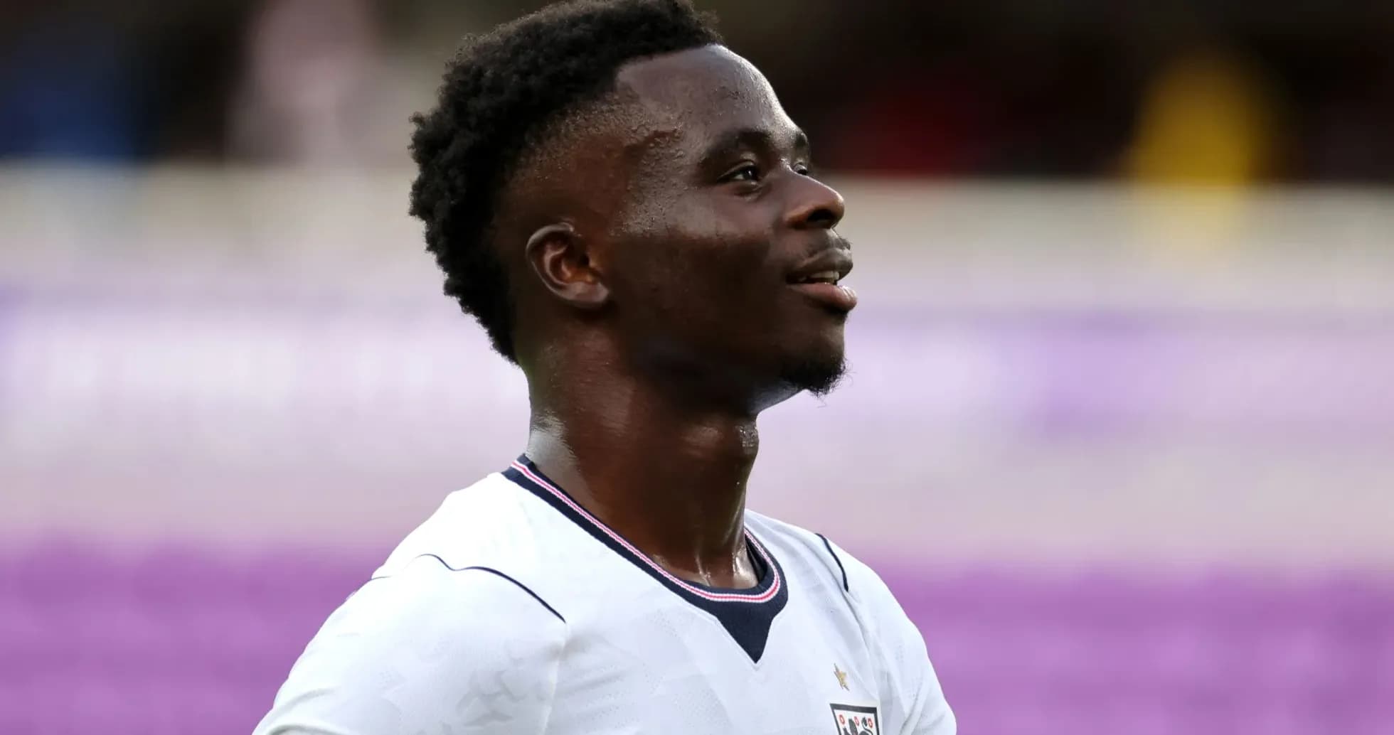 Joueur en maillot blanc souriant sur le terrain Joueur en maillot blanc souriant sur le terrain
