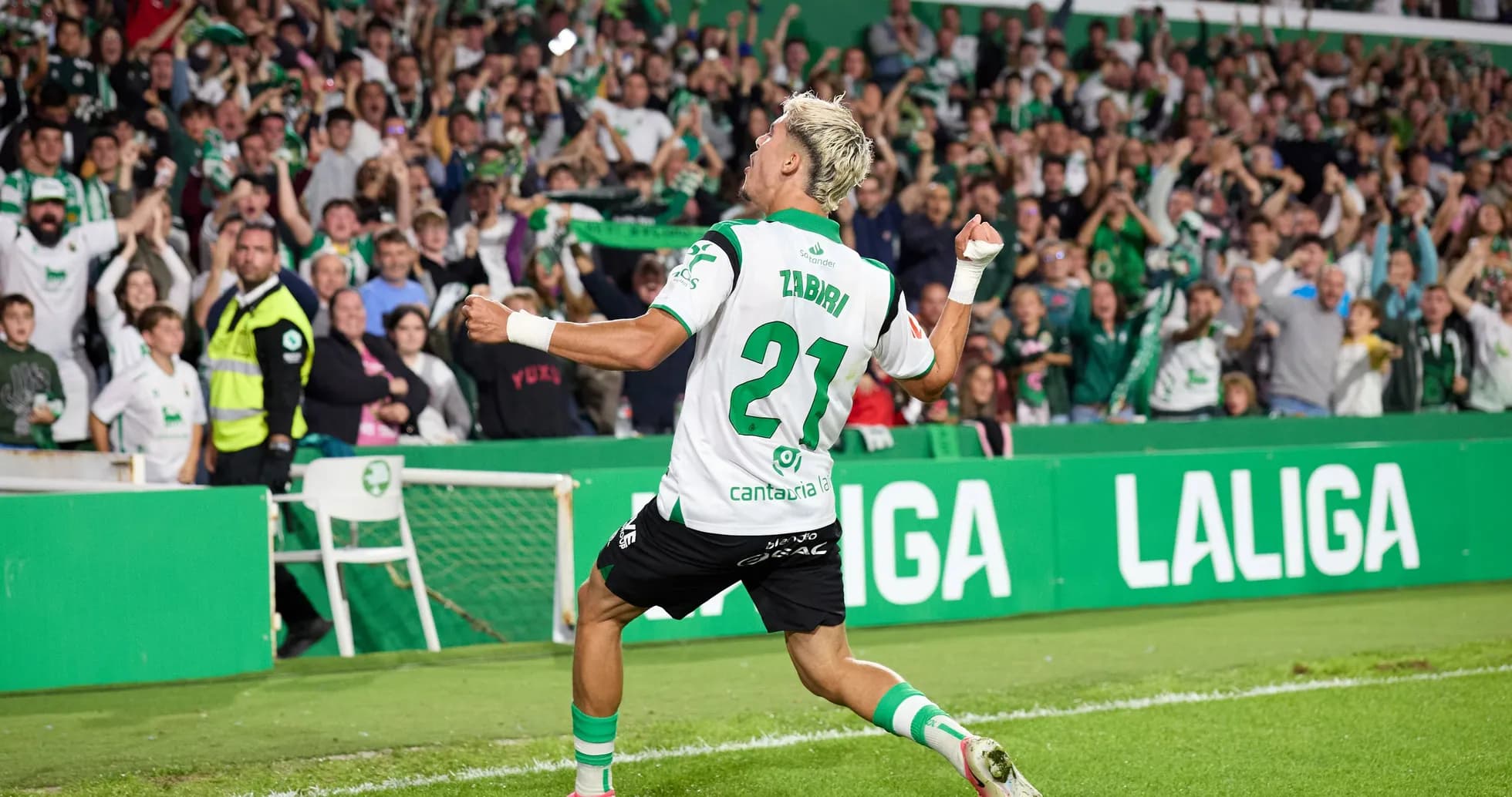 Joueur célébrant un but devant des supporters enthousiastes Joueur célébrant un but devant des supporters enthousiastes
