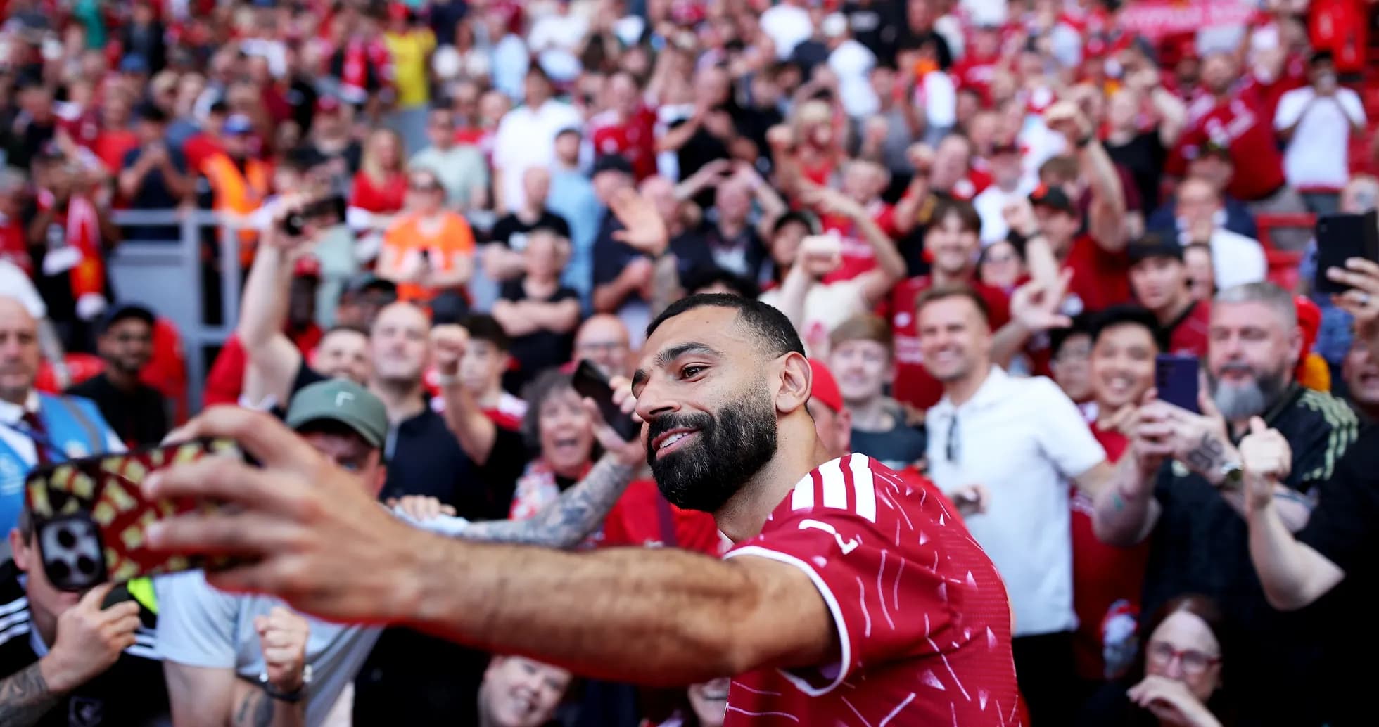 Joueur prenant un selfie avec des fans en arrière-plan Joueur prenant un selfie avec des fans en arrière-plan