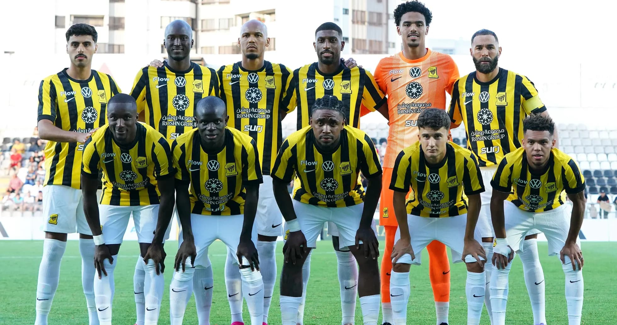 Équipe de football en tenue jaune et noire en pose Équipe de football en tenue jaune et noire en pose