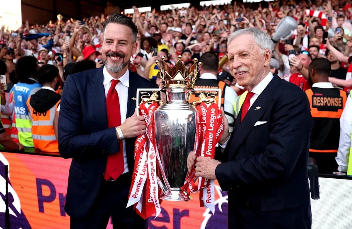 Deux personnes tenant le trophée de la Premier League Deux personnes tenant le trophée de la Premier League
