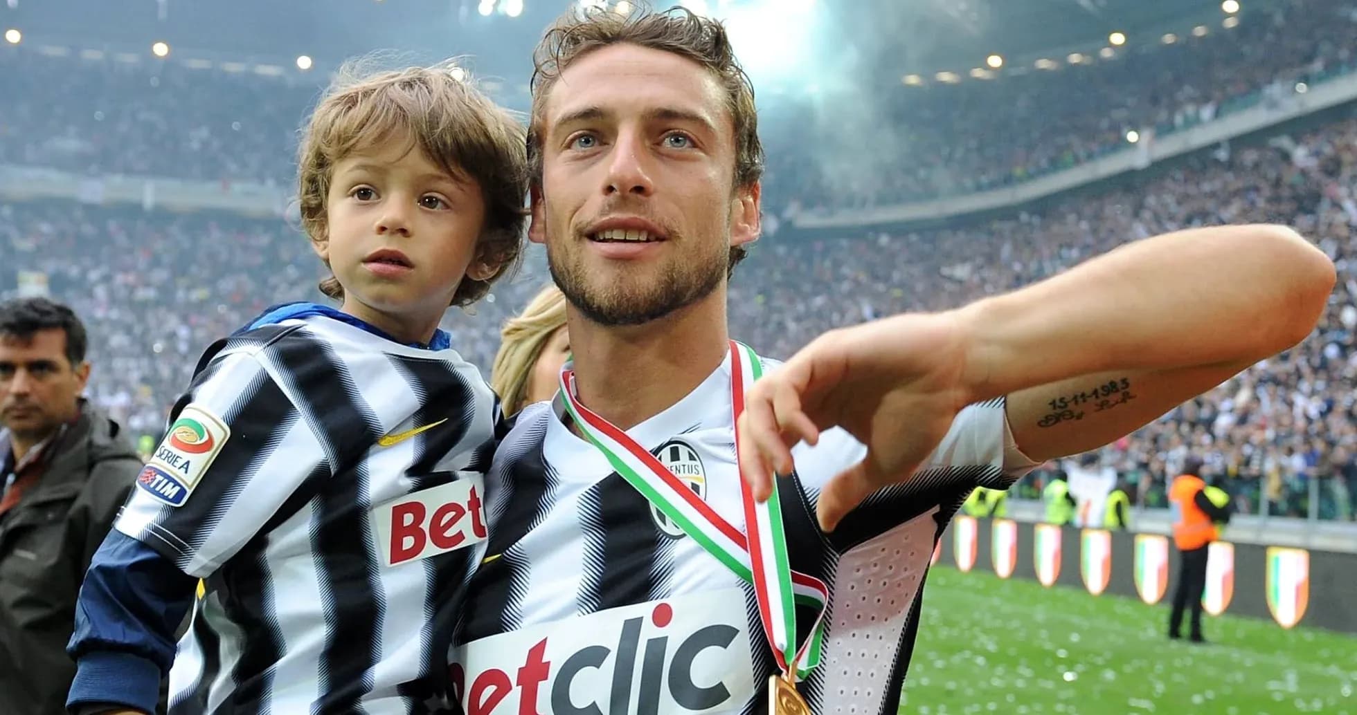 Joueur de football tenant un enfant sur le terrain Joueur de football tenant un enfant sur le terrain