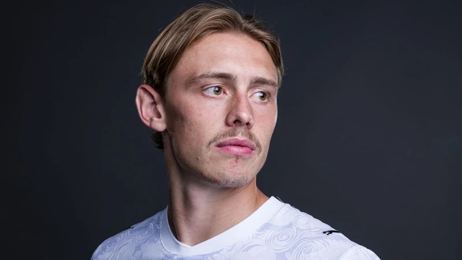 Joueur de football en maillot blanc, regardant à droite Joueur de football en maillot blanc, regardant à droite