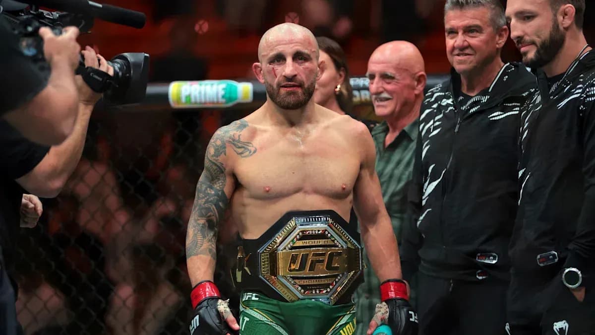 Fighter holding UFC championship belt in octagon Fighter holding UFC championship belt in octagon