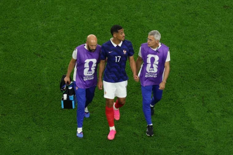 Joueur de France accompagné par entraîneurs sur le terrain Joueur de France accompagné par entraîneurs sur le terrain