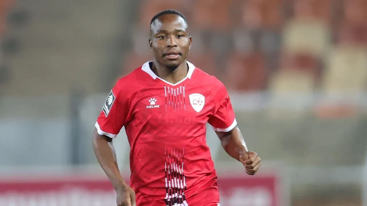 Joueur en maillot rouge courant sur le terrain Joueur en maillot rouge courant sur le terrain