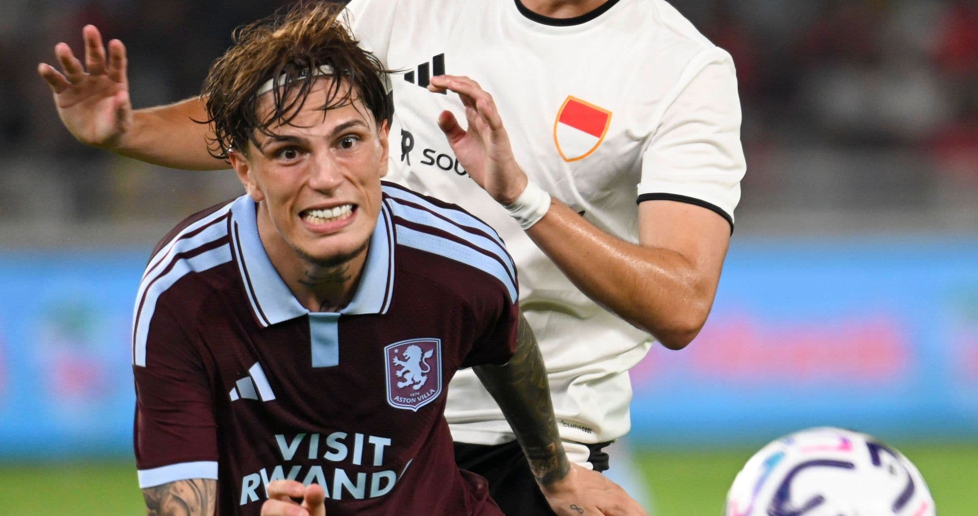 Joueur d'Aston Villa poursuivi par un adversaire Joueur d'Aston Villa poursuivi par un adversaire