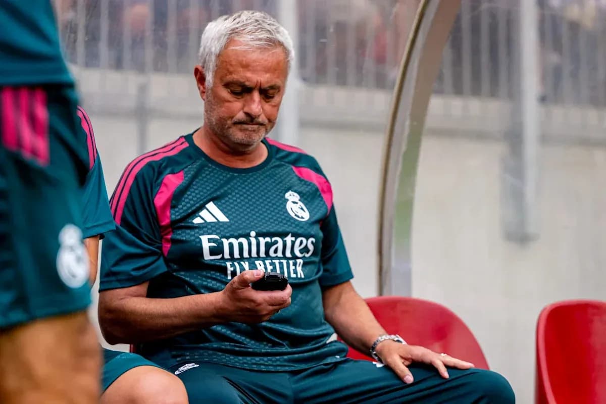 Entraîneur assis sur le banc, regardant son téléphone Entraîneur assis sur le banc, regardant son téléphone